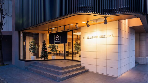 A modern hotel entrance with a sign reading "HOTEL ABANT SHIZUOKA," featuring a clean, contemporary design with a tiled facade and a welcoming entrance with steps. - Hotel Abant Shizuoka (Shizuoka)