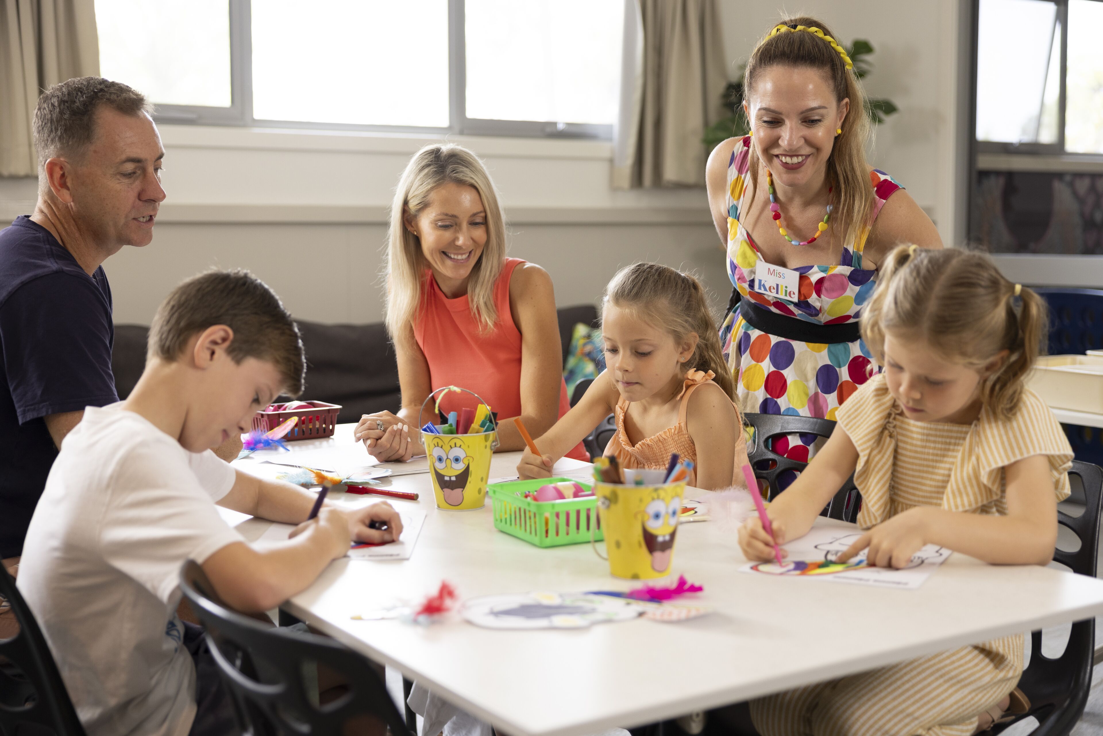 Une famille de quatre personnes participait à une activité créative autour d’une table où étaient disposés du matériel d’art.
