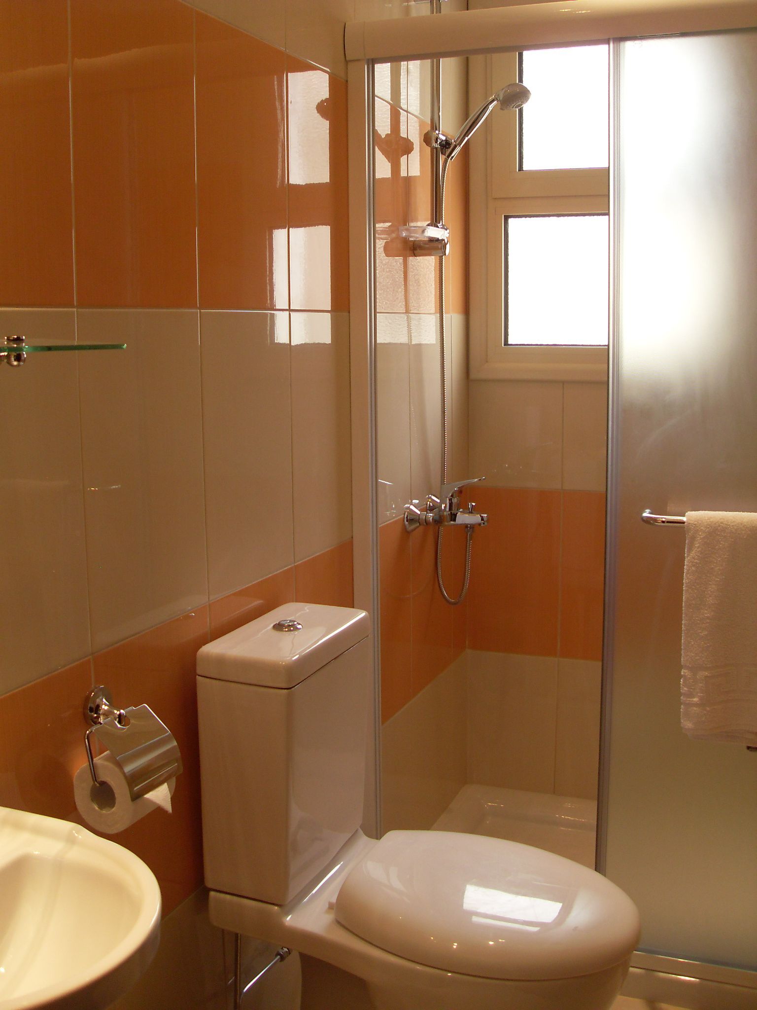 A bathroom with a toilet, sink, and shower.