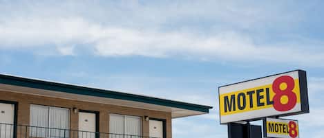 Un motel con un letrero que dice 'Motel 8' y un letrero más pequeño debajo.