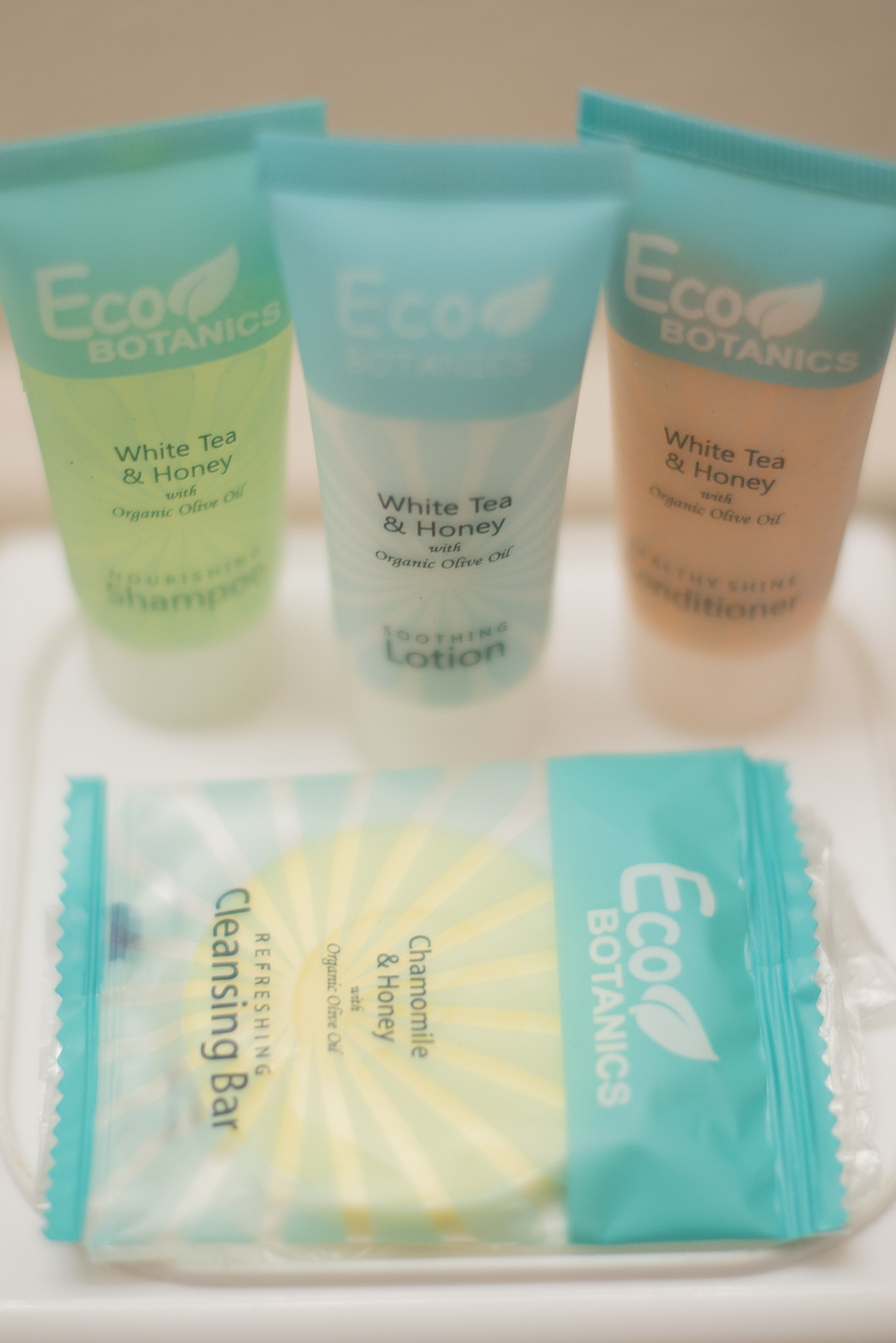 Three Eco Botanics products: a white tea and honey shampoo, a white tea and honey lotion, and a chamomile and honey cleansing bar.