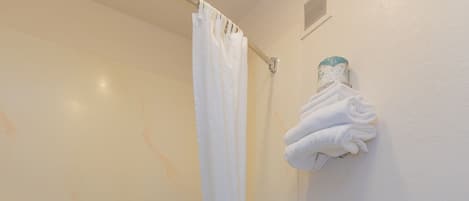 Un baño con bañera, inodoro y cortina de ducha.