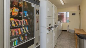 Un distributeur automatique de collations, un réfrigérateur, un four à micro-ondes et un évier sont à disposition dans un petit coin cuisine.