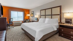 A hotel room with a large bed, a desk, a chair, a desk lamp, a bedside table, and a window with a view. - Holiday Inn Express Hotel & Suites Albert Lea - I-35 by IHG (Albert Lea)