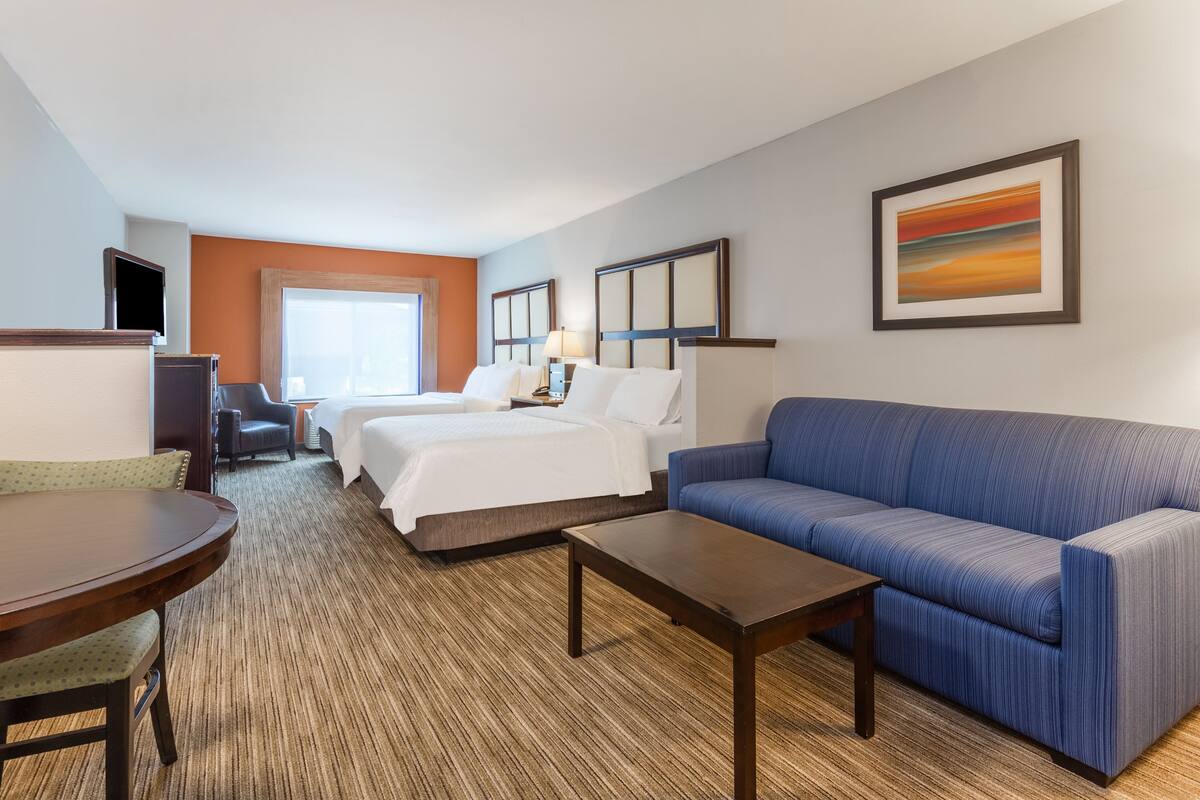 Een hotelkamer met een bed, een bank, een bureau en een stoel.