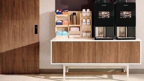 A modern kitchen with wooden cabinets, a white countertop, and two coffee machines. - Holiday Inn Express Hotel & Suites Albert Lea - I-35 by IHG (Albert Lea)