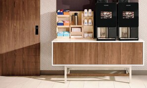 A modern kitchen with wooden cabinets, a white countertop, and two coffee machines. - Holiday Inn Express Hotel & Suites Albert Lea - I-35 by IHG (Albert Lea)