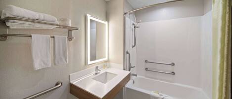 Un baño moderno con lavabo, espejo y ducha.