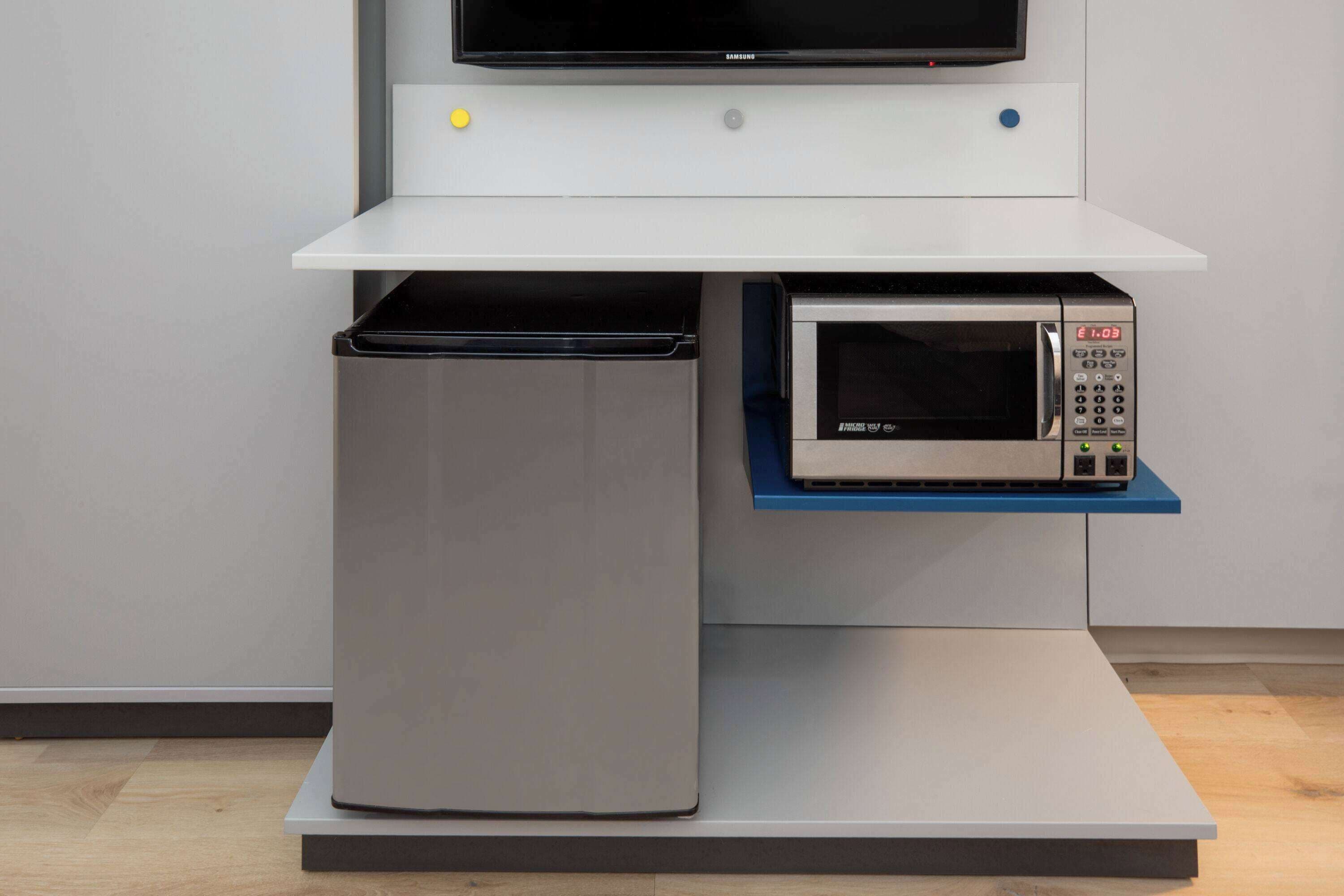 A kitchen with a microwave and a built-in oven on a white countertop.