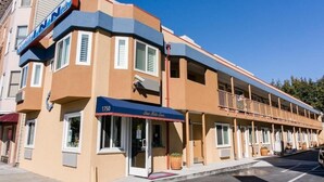 A motel with a blue awning and a sign reading "Sea Side Inn."