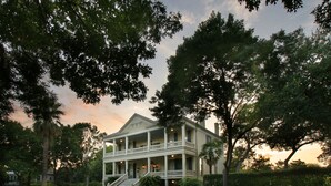 A two-story colonial-style building with a central balcony and a staircase leading to the entrance. - Noble Inns (San Antonio)
