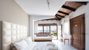 Quarto de hotel com uma cama grande, vista para o mar e teto de madeira.