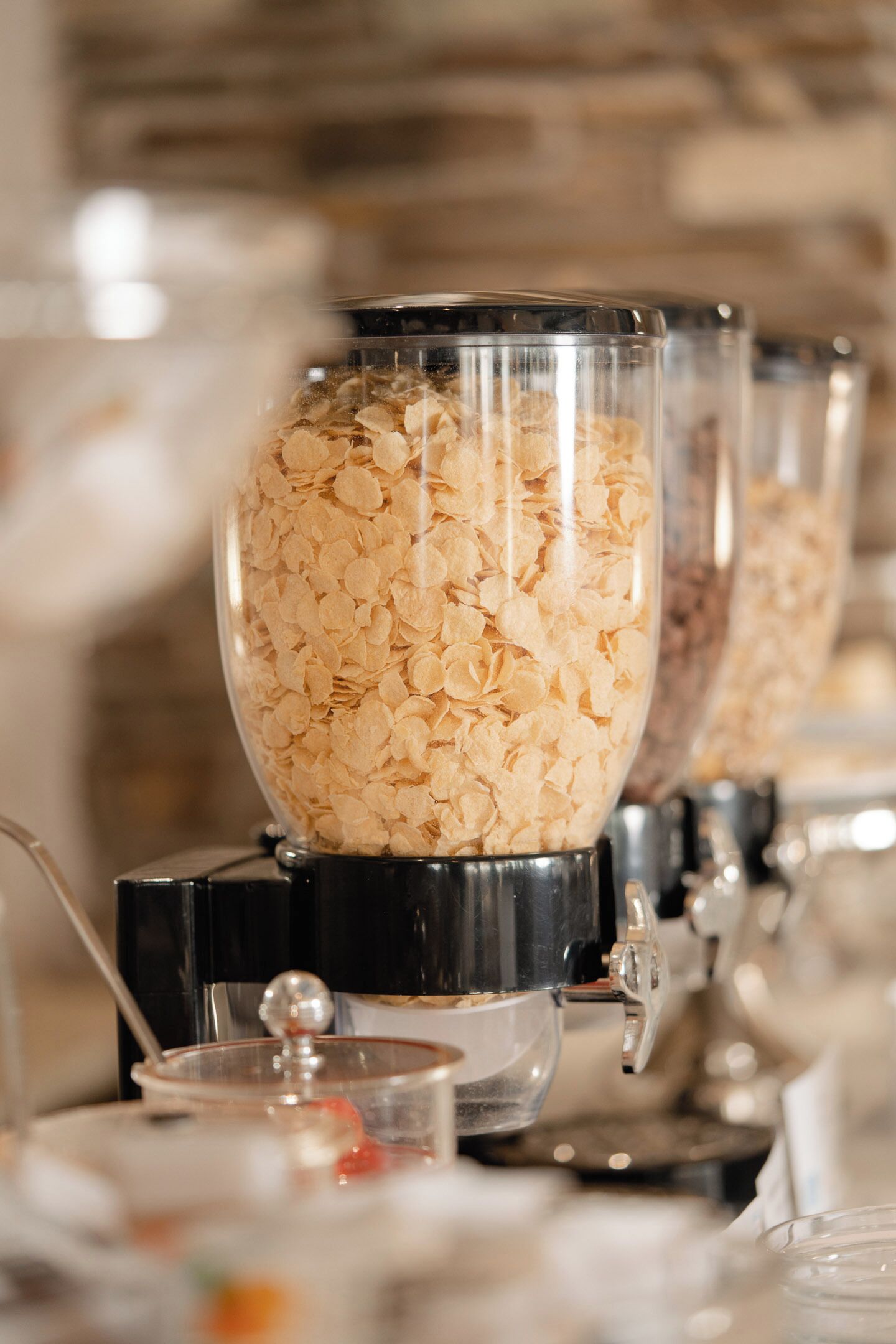 Un bufé de desayuno con dispensadores de cereales.