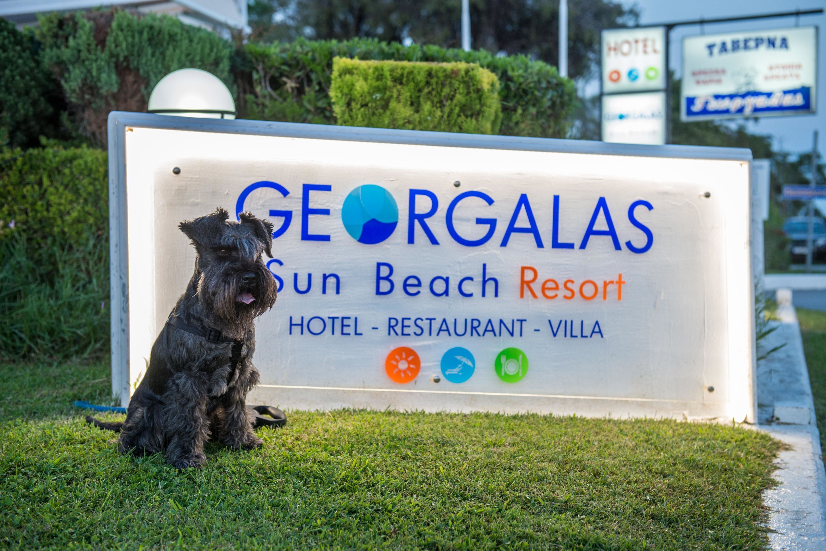 A sign for Georgalas Sun Beach Resort, indicating it offers a hotel, restaurant, and villa.