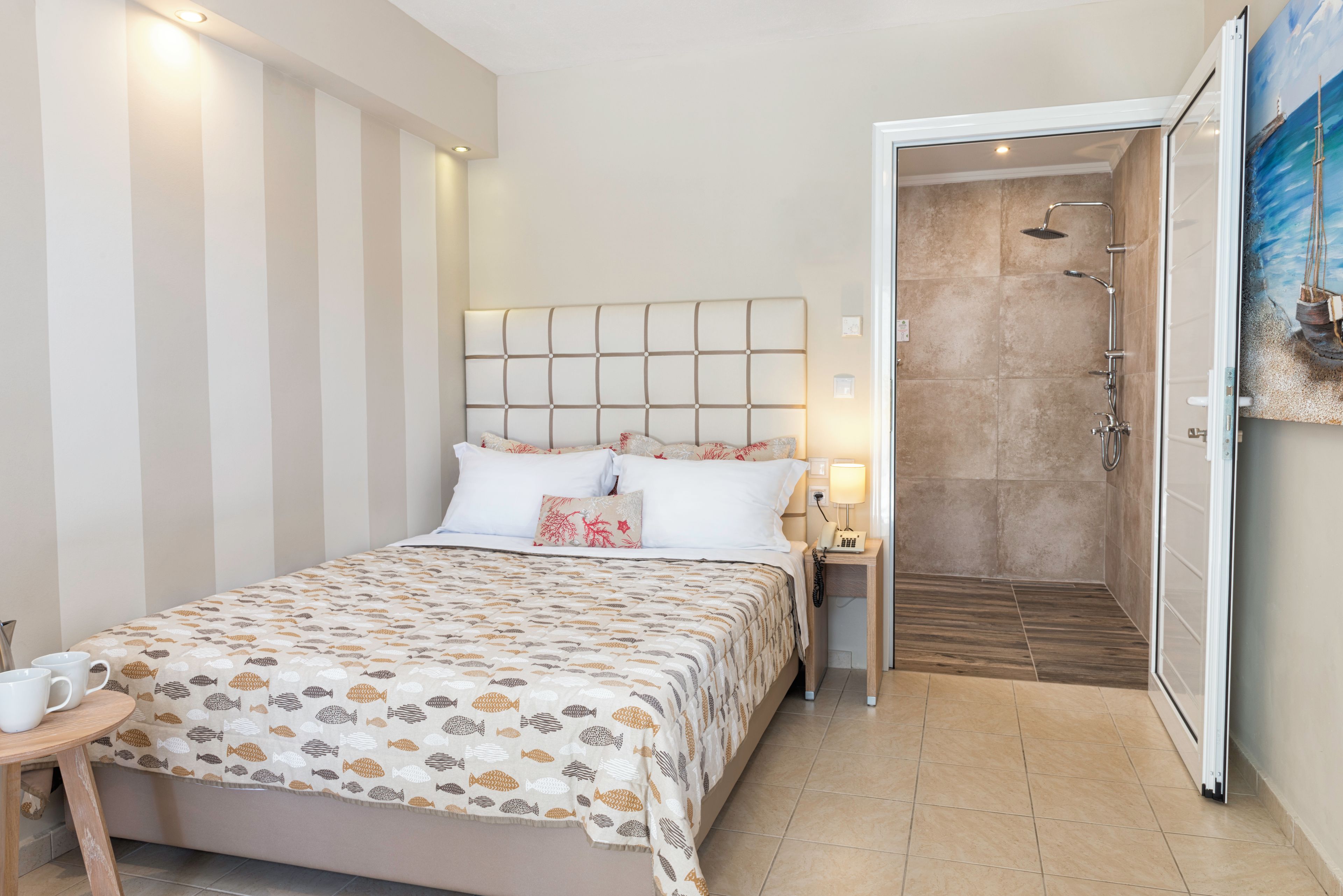 A hotel room with a bed, bedside table, and a shower area.