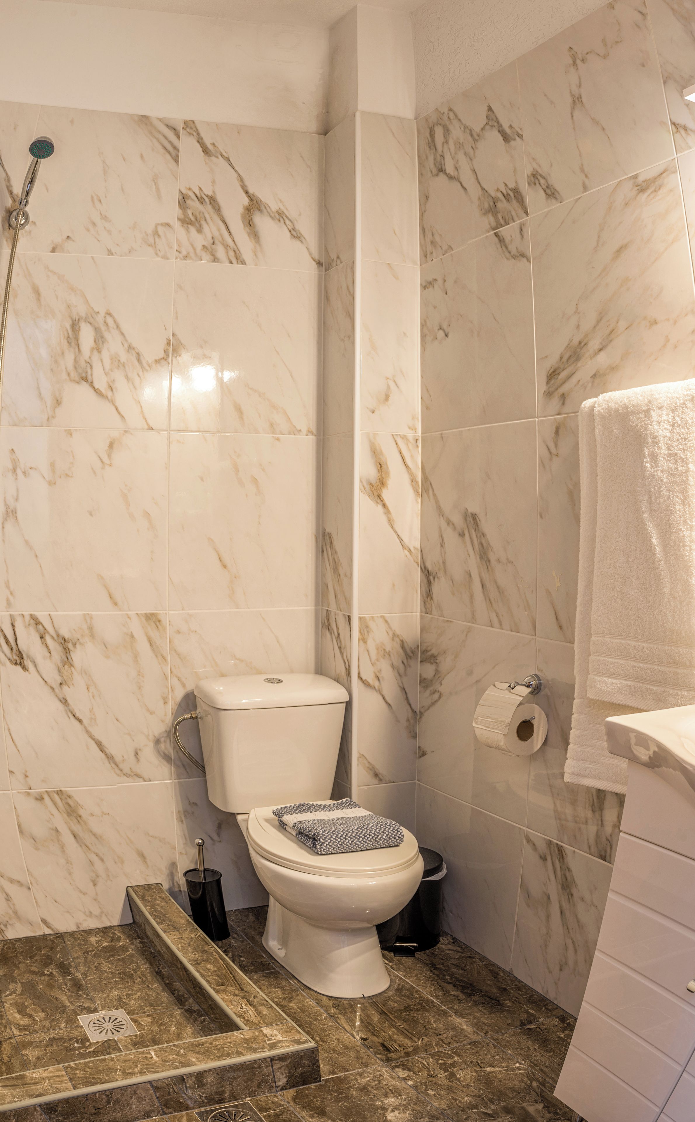 Un baño con inodoro, ducha y lavamanos.