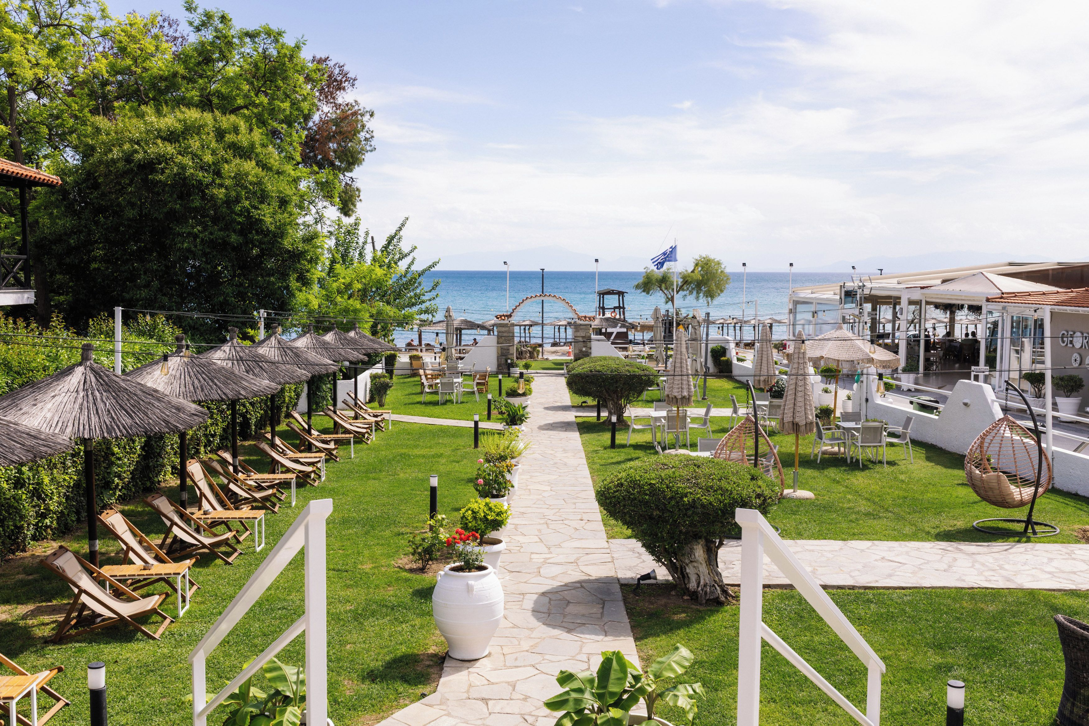 A pathway leading to a beachside seating area with umbrellas and lounge chairs.