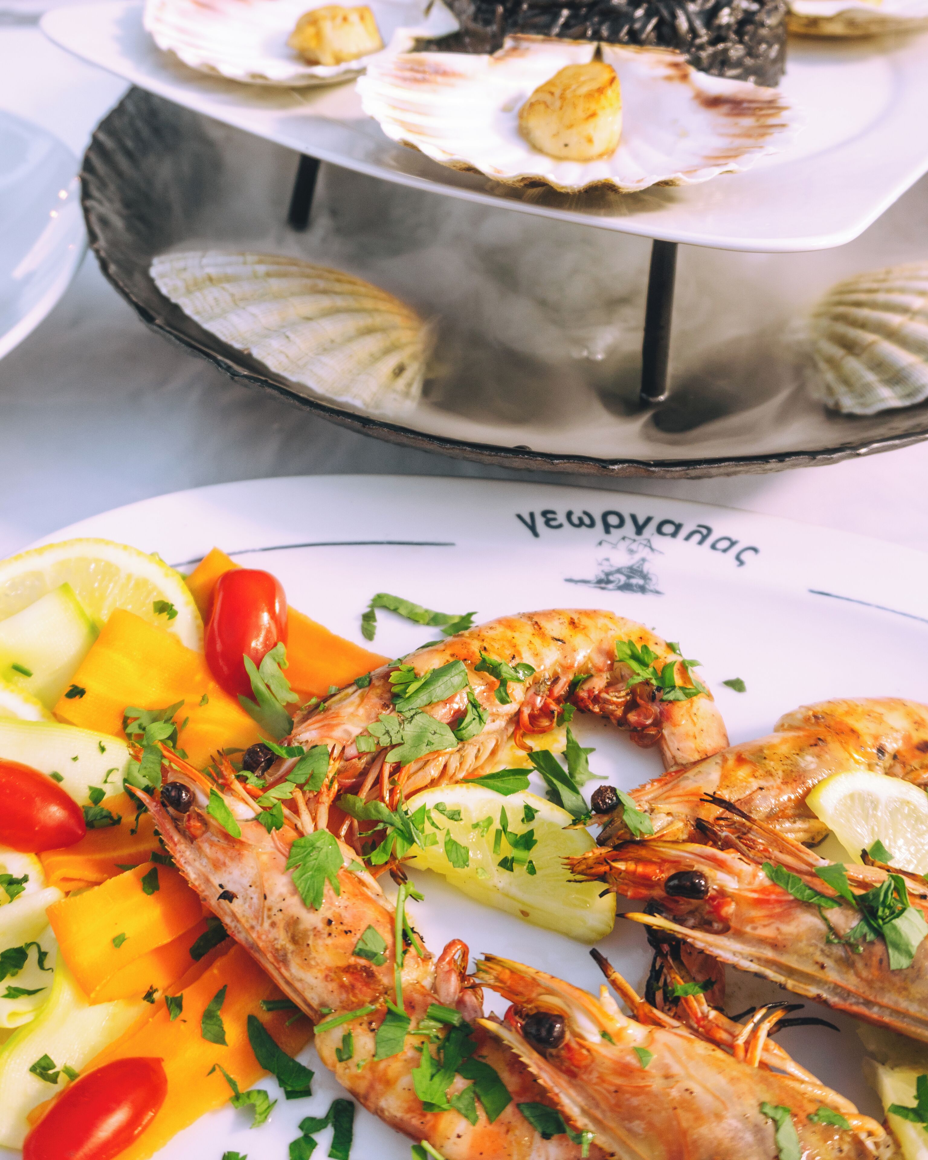 Un plato de mariscos con camarones, limón y verduras.