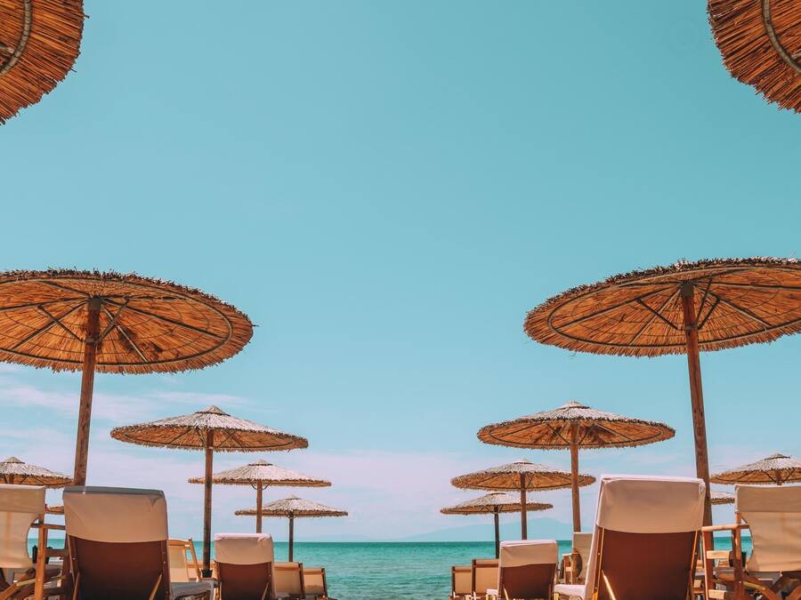 Na praia, espreguiçadeiras, guarda-sóis, bar na praia