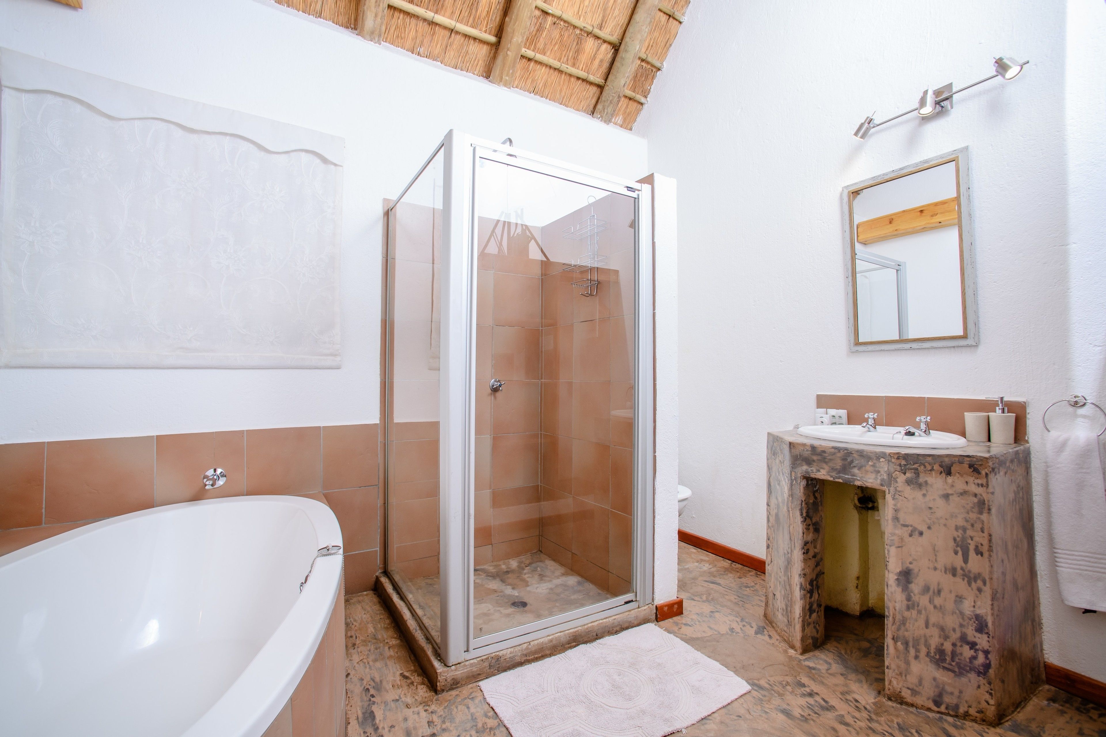 Een badkamer met een douchecabine van glas, een bad en een wastafel.