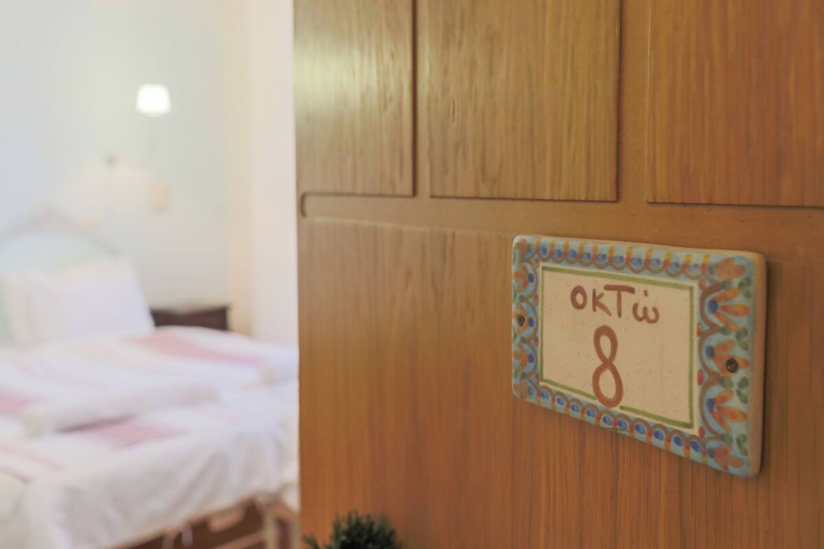 Eine Holzwand mit einem dekorativen Schild, auf dem 'OKT 8' steht.