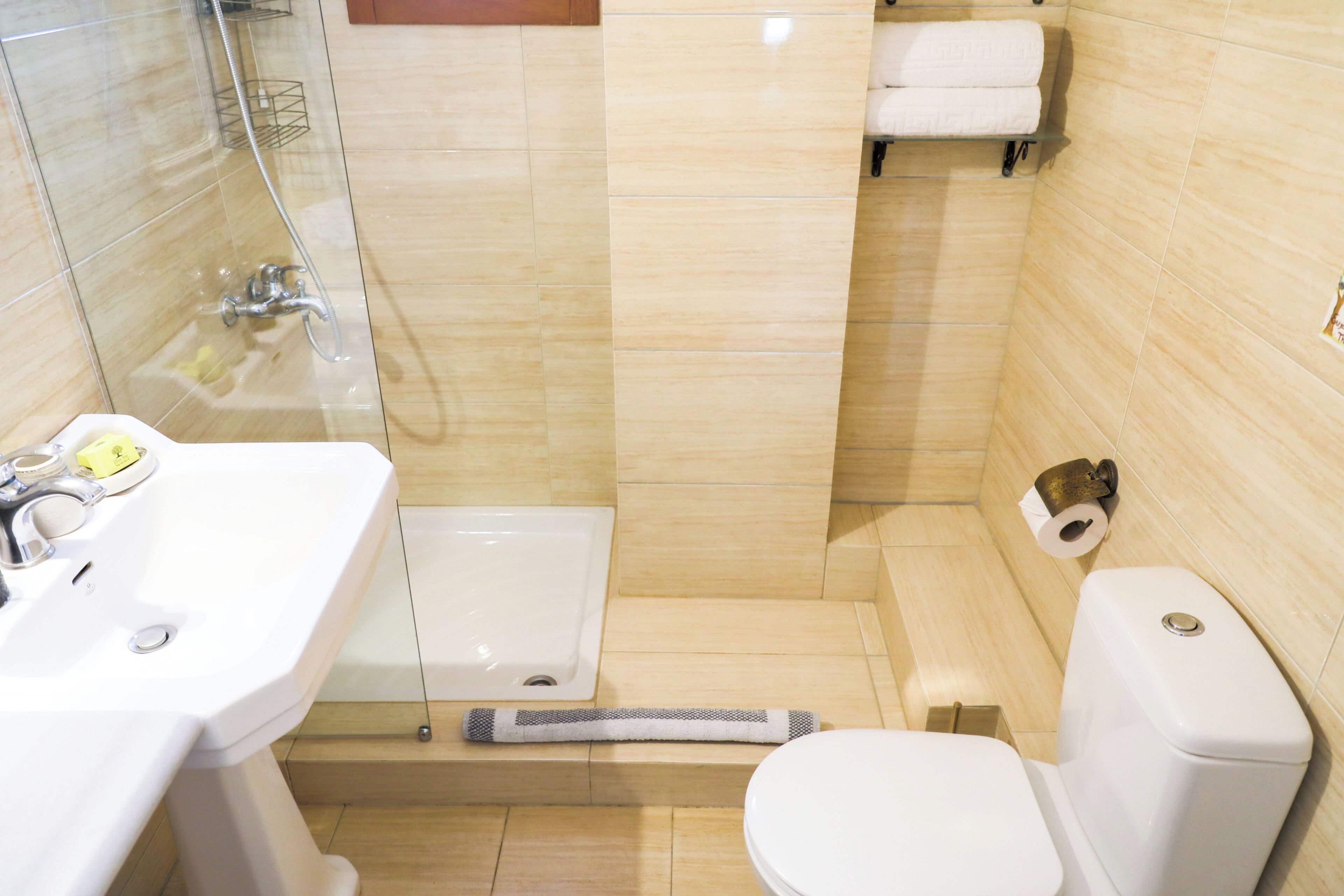 A bathroom with a sink, toilet, and shower area.