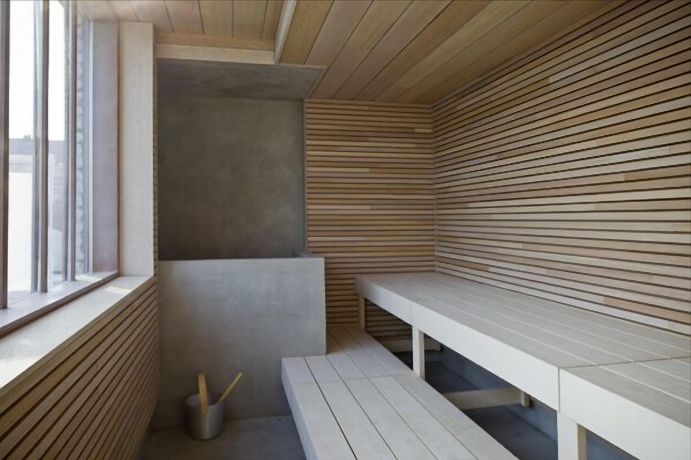 Une salle de spa moderne, dotée d’un banc, d’une fenêtre et d’un mur en lambris de bois.