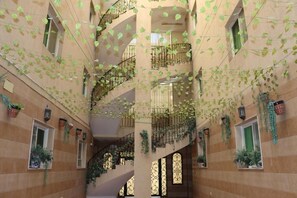 A multi-level atrium with balconies, staircases, and potted plants.