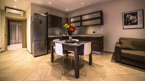 Una cocina moderna con una mesa de comedor, sillas y un jarrón de flores.