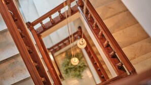 A staircase with a wooden railing and a hanging light fixture. - Hotel San Lorenzo (Santiago de Compostela)