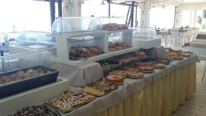 A buffet with various food items including pastries, pies, and cakes.