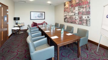 A conference room with a long table, several chairs, water bottles, and a whiteboard.