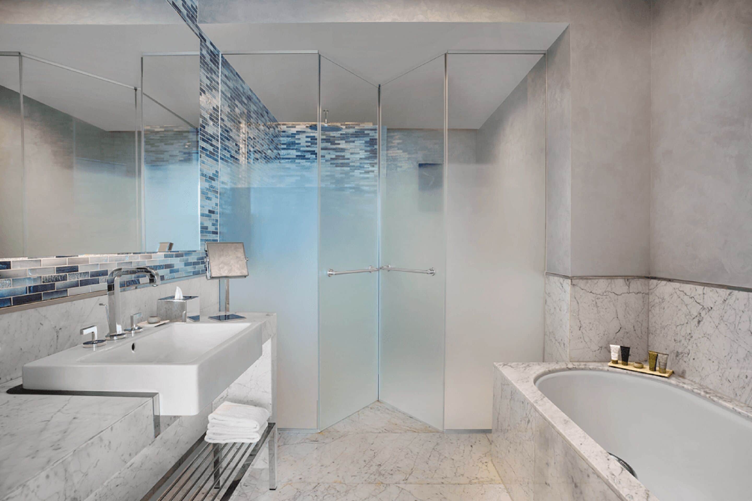 Ein modernes Badezimmer mit Duschkabine aus Glas, einer großzügigen Badewanne und einem Waschtisch mit Spüle und Spiegel.