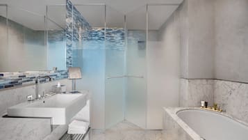 Ein modernes Badezimmer mit Duschkabine aus Glas, einer großzügigen Badewanne und einem Waschtisch mit Spüle und Spiegel.