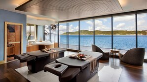 A modern room with a large window overlooking a body of water, a wooden ceiling, and a seating area with a table and chairs. - The Grand Tarabya Managed by Accor (Sariyer)