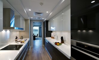 Una cocina moderna con una isla central, electrodomésticos de acero inoxidable y vistas al exterior.
