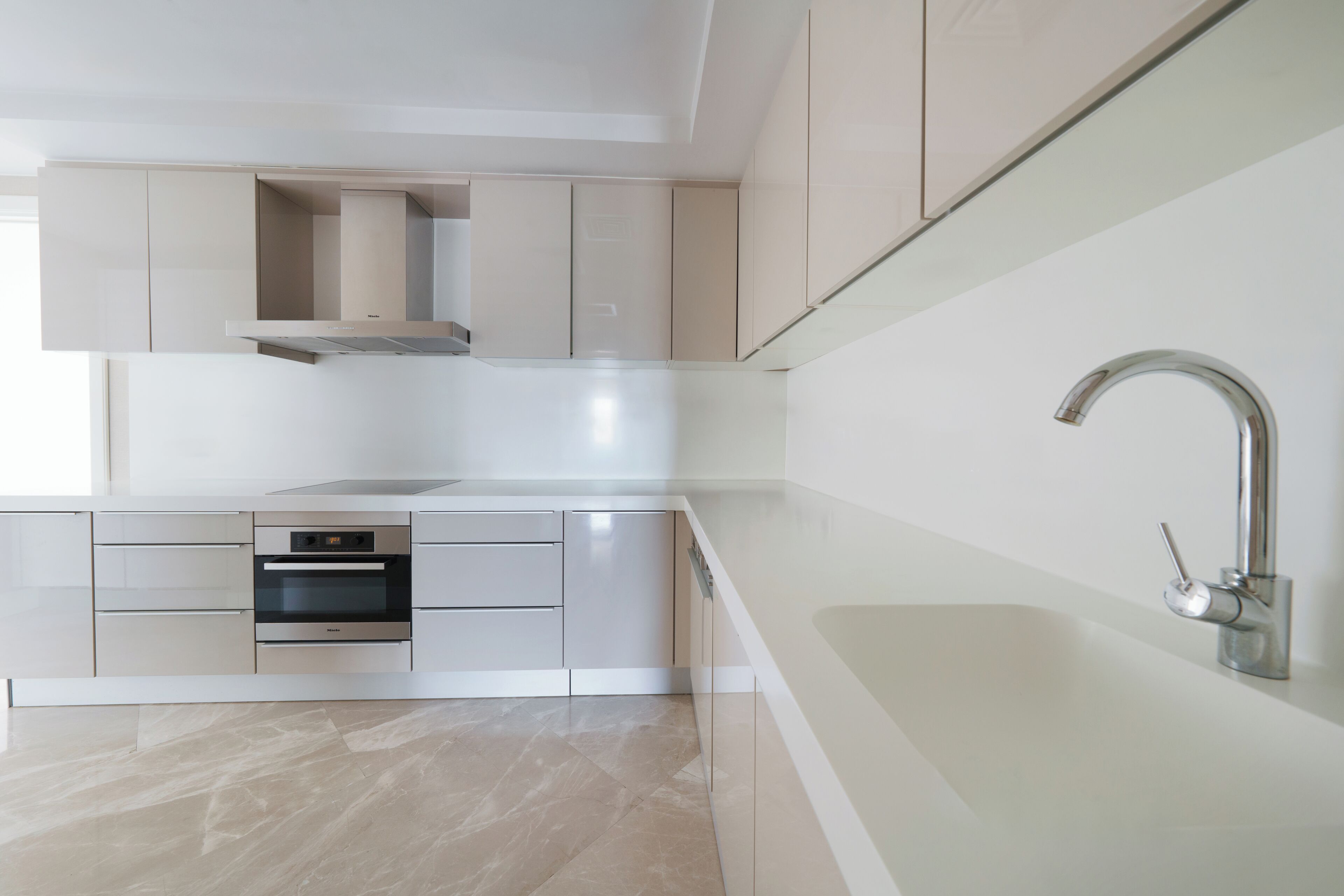 A modern kitchen with stainless steel appliances, a built-in oven, and a sleek faucet.