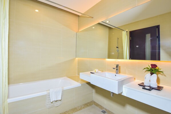 Un baño moderno con bañera, dos lavamanos y un espejo.