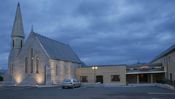 En kyrka med ett torn och en byggnad bredvid som har skylten ”The Fort Lounge”.
