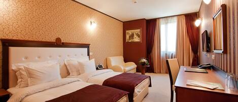 Een hotelkamer met twee bedden, een bureau, een stoel, een televisie en een spiegel.