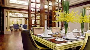 Une salle à manger élégante, avec une longue table dressée pour accueillir de nombreux convives, agrémentée d’un arrangement floral central et d’une décoration de table raffinée.