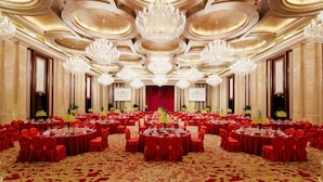 Une salle de banquet avec des tables rondes, des nappes rouges et des lustres.