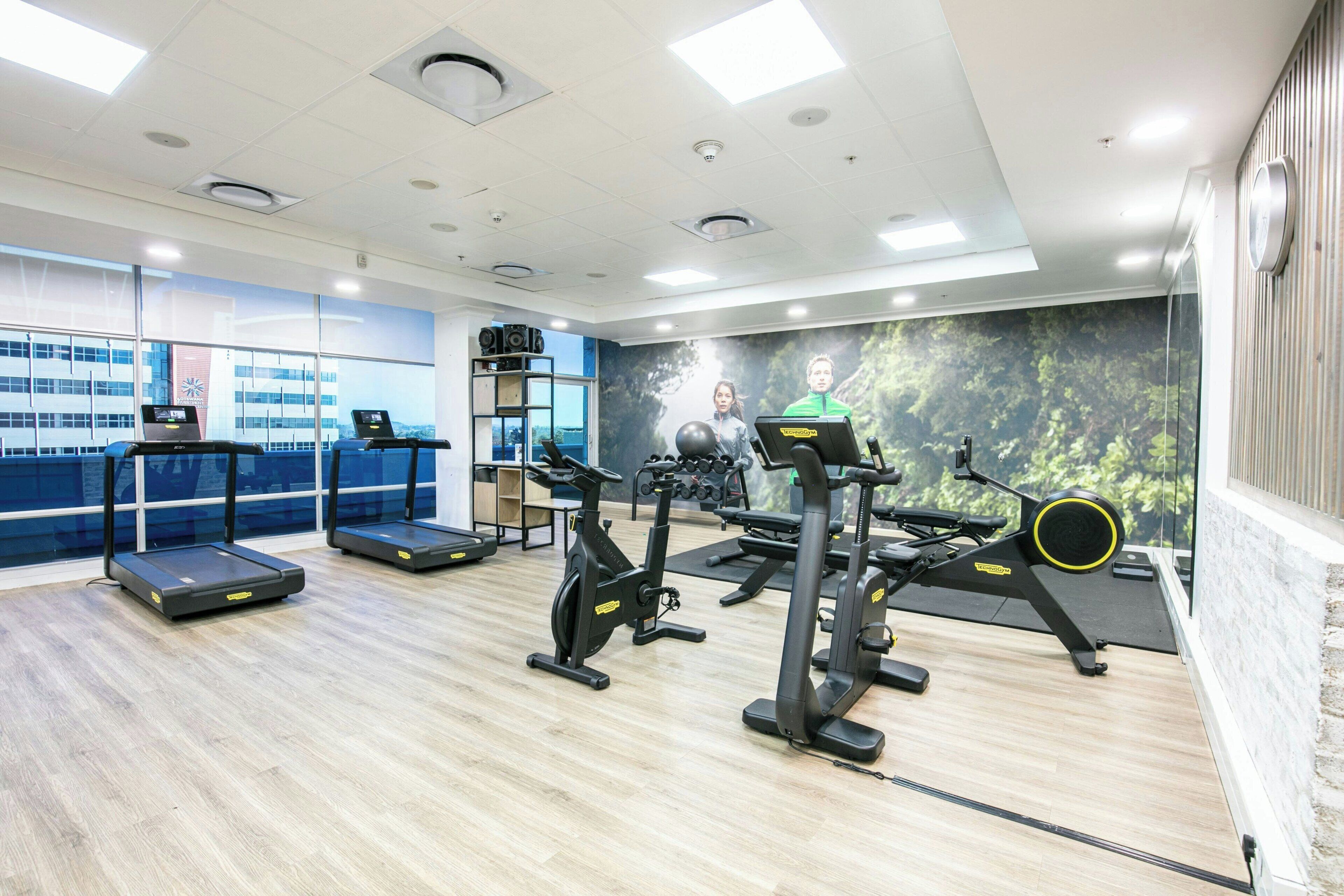 Een moderne sportschool met loopbanden, hometrainers en krachttoestellen.