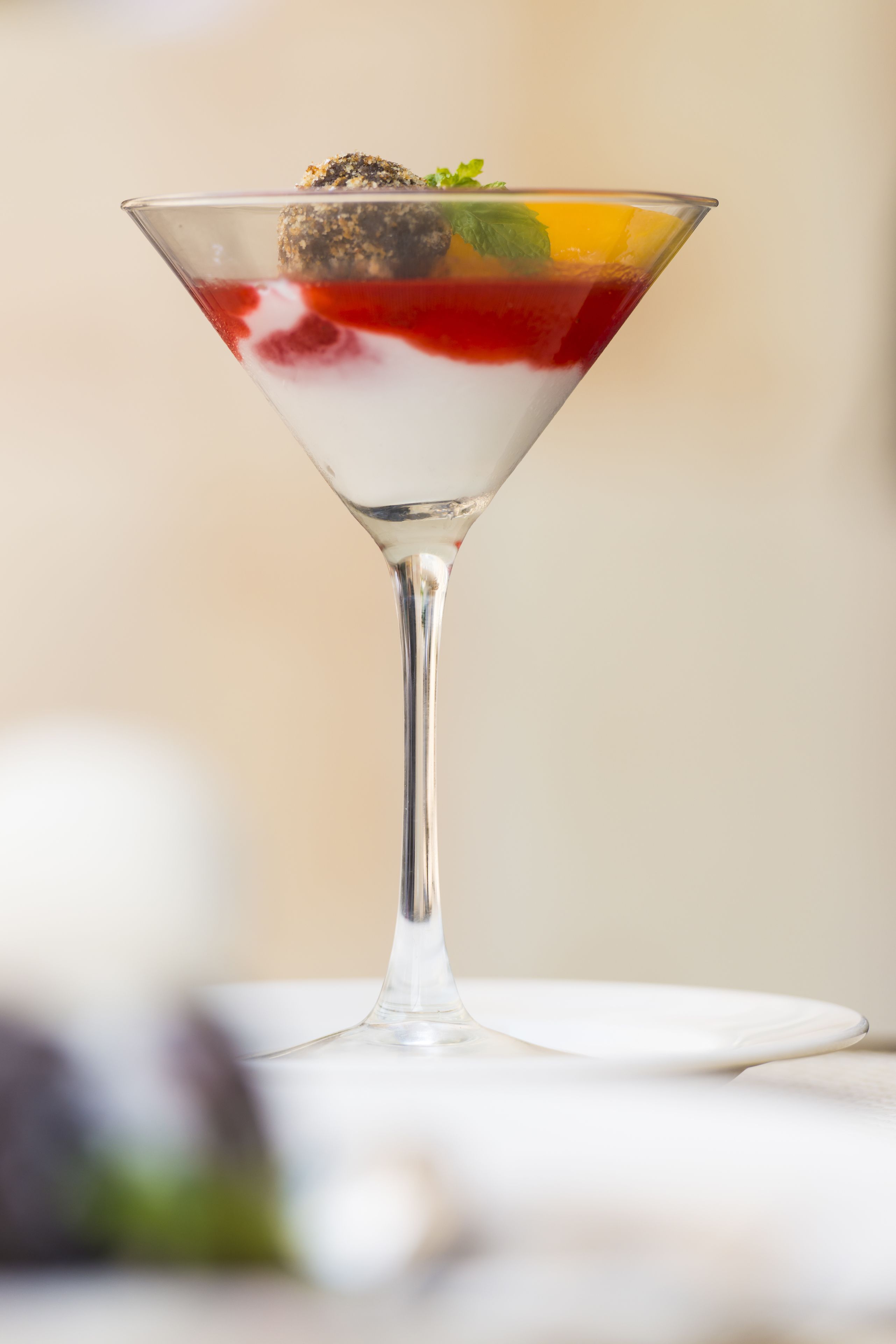 Una copa de martini con un postre en capas sobre un plato blanco.
