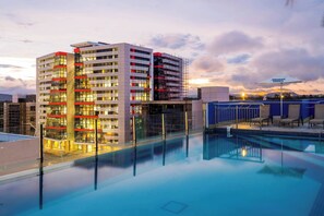 Alberca al aire libre, sombrillas en la alberca y camastros 