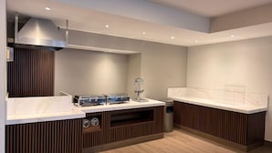 Une cuisine moderne dotée d’une cuisinière intégrée, d’un évier et d’un plan de travail avec un pare-feu en marbre.
