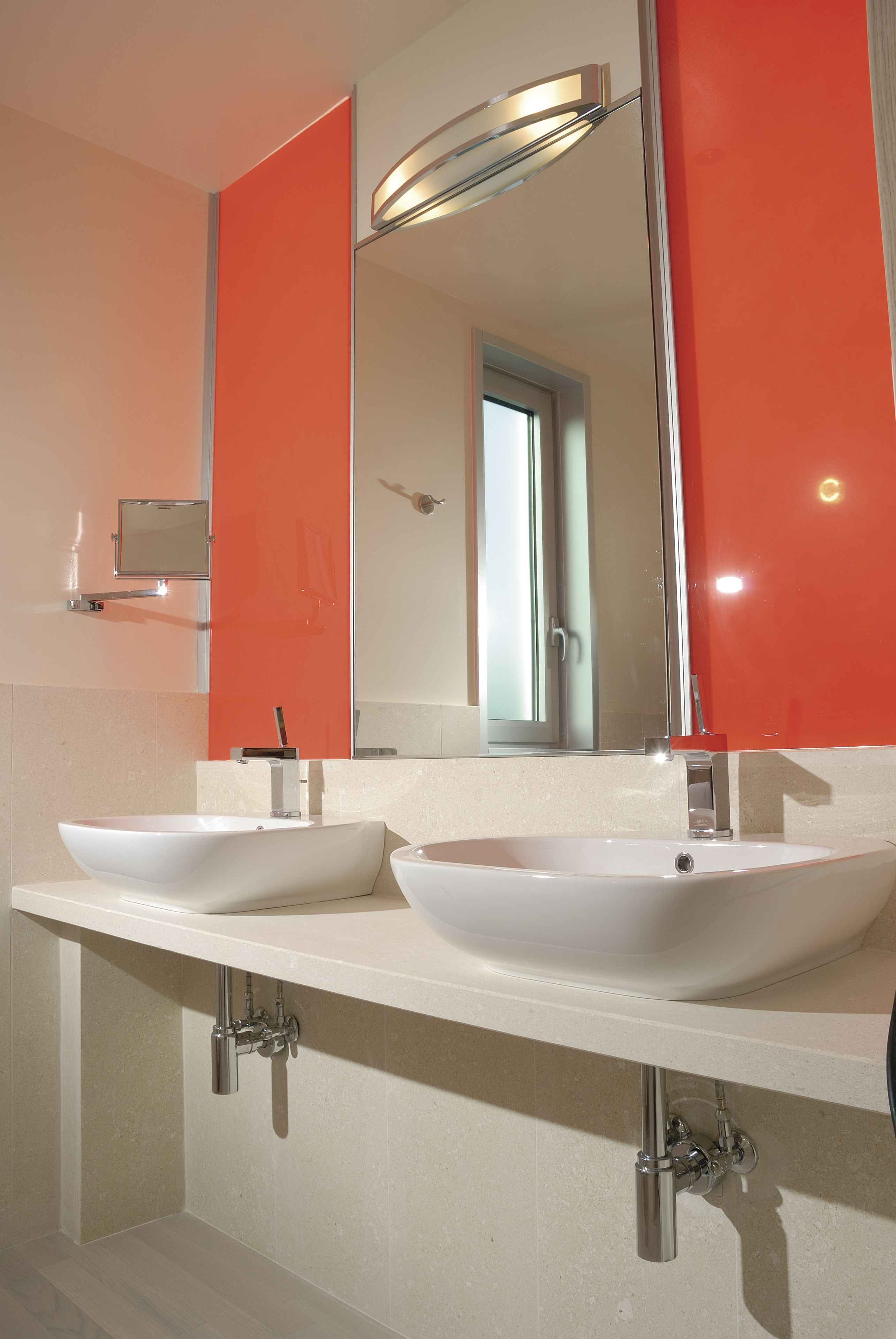 A bathroom with two sinks, a mirror, and a shower.