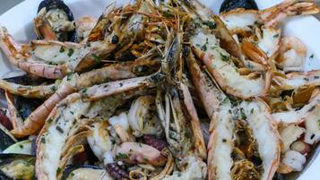 A seafood platter with various shellfish, including shrimp and mussels, garnished with herbs.