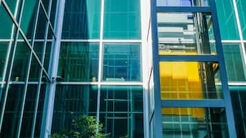 A modern building with a glass facade and a central elevator shaft.