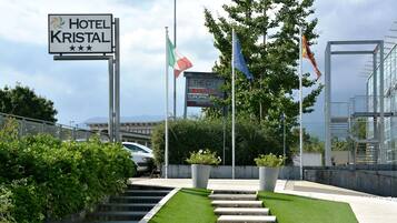 Hotellin sisäänkäynti, jossa on kyltti, jossa lukee ”HOTEL KRISTAL”, sekä lippuja, mukaan lukien Italian lippu.